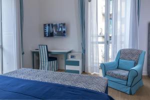 een slaapkamer met een bed, een stoel en een bureau bij Mya Home Luxury Apartments in Castellammare di Stabia