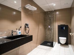 a bathroom with a sink and a toilet and a shower at Quality Hotel Grand Royal in Narvik +77 photos