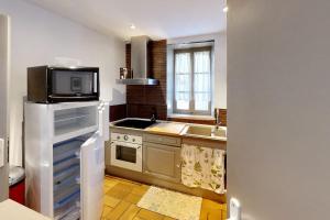 une cuisine avec un micro-ondes et une cuisinière four supérieur dans l'établissement Maison de Village Chez Popeye, à Vogüé 2 autres photos