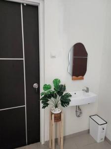ein Badezimmer mit einem Waschbecken und einer Topfpflanze in der Unterkunft Baturu Villa Kayana Regency D9 Dekat Jatim Park 3 in Batu + 21 Fotos