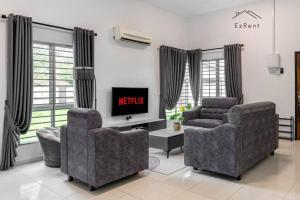 a living room with two chairs and a television at Semi-D Black & White Retreat with Free NetFlix WiFi in Taiping +24 photos