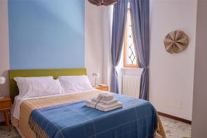 a bedroom with a blue bed with towels on it at Gigi' Studio in Verona +4 photos