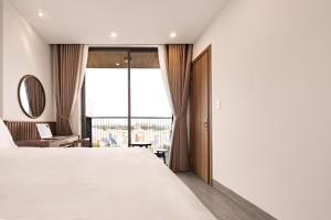 a bedroom with a large white bed and a window at Hoàng Thịnh Hotel & Apartment Danang in Danang