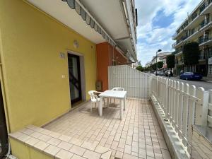 een witte tafel en stoel op het balkon van een gebouw bij Marconi Bilocale - Agenzia Cocal in Caorle +3 foto's