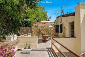 een patio met een tafel en een parasol bij Reborn House, TerreMarine in La Spezia