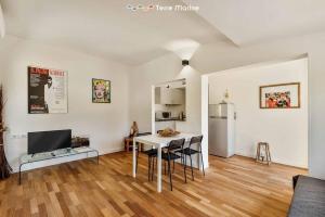 een woonkamer met een tafel en een koelkast bij Reborn House, TerreMarine in La Spezia