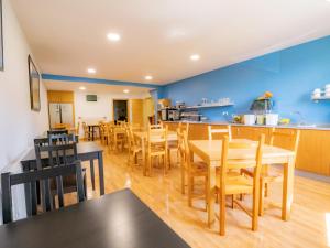 a dining room and kitchen with wooden tables and chairs at Pensión Palas in Palas de Rei