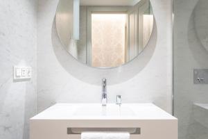 a white bathroom with a sink and a mirror at "La Bella Easo" new, ac, design, near La Concha in Donostia-San Sebastián +27 photos