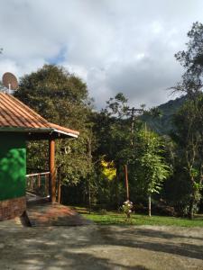 a pavilion in a yard with trees in the background at Chalé da Flor in Visconde De Maua