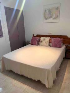 a bedroom with a large bed with pillows on it at Bungalow in Calpe - swimming pool and tennis court in Calpe +6 photos