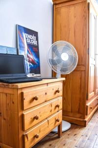 a laptop computer on a dresser with a fan at Quartier Arago - Maison 3 chambres plage à pied in Les Sables-dʼOlonne