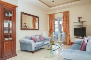 a living room with two blue couches and a mirror at Kostoula's House Beachfront in Stalos