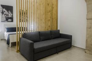 a black couch in a room with a bed at Marinusa home luxury - air conditioned - wi-fi in Siracusa