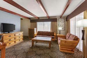 a living room with a couch and a television at Best Western Mission Inn in Las Cruces