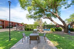 a patio with a table and chairs in a park at Best Western Mission Inn in Las Cruces