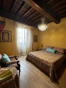 a bedroom with a bed and a chandelier at Historic apartment in Bucine