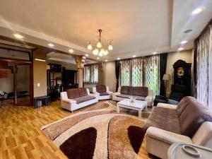 a large living room with couches and a rug at Mountain Garden House in Prizren