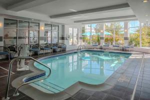 una piscina en una habitación de hotel con sillas alrededor en Hilton Garden Inn Freeport Downtown, en Freeport