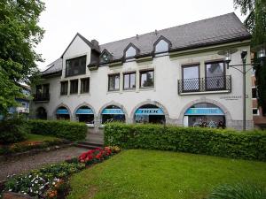 ein großes weißes Gebäude mit einem Garten davor in der Unterkunft Ferienwohnung Amperblick Fürstenfeldbruck in Fürstenfeldbruck