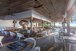 a restaurant with tables and chairs on a deck at Hilton at Resorts World Bimini in Alice Town