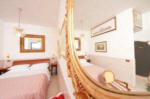 ein Hotelzimmer mit 2 Betten und einem Spiegel in der Unterkunft Terrazza San Pietro in Rom