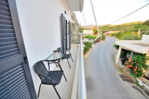 a balcony with two chairs and a street at Anatoli Apartment in Kissamos