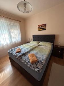 a bedroom with a bed with two pillows on it at Vámos Apartman in Bük