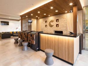 a lobby with a bar with stools at Comfort Hotel Nagoya Meiekiminami in Nagoya