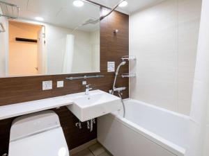 a bathroom with a sink and a toilet and a tub at Comfort Hotel Nagoya Meiekiminami in Nagoya