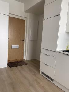 a room with white cabinets and a wooden door at Snowflake Suites IV in Rovaniemi