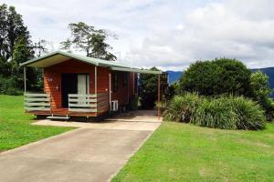 a small wooden cabin with a green roof at Mountain Edge Escape in Eungella