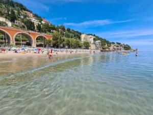 a beach with a bunch of people in the water at Casa Santiago in Alassio