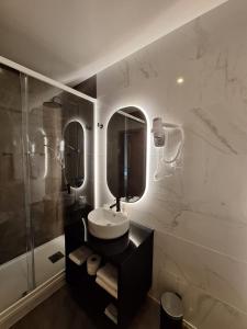 a bathroom with a sink and two mirrors and a shower at Hotel Alicante Lisboa in Lisbon +37 photos