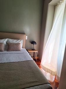 a bedroom with a large bed and a window at Hotel Alicante Lisboa in Lisbon
