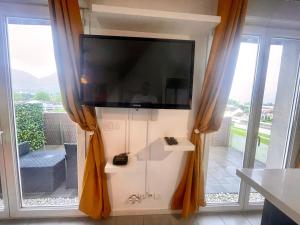 a television on a wall in a room with windows at Neyrpic - Cocon douillet -balcon in Rhut