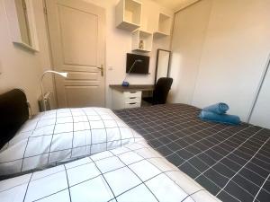 a bedroom with a bed in a room with a desk at Neyrpic - Cocon douillet -balcon in Rhut