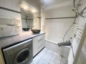 a bathroom with a washing machine and a bath tub at Neyrpic - Cocon douillet -balcon in Rhut +10 photos
