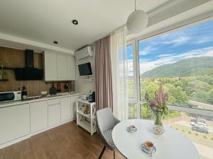 a kitchen with a table and a large window at "АпартСервic" жк Сонячний квартал in Solochin