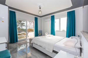 Un dormitorio blanco con cortinas azules y una cama. en Villa Riveria, en Kas 16 fotos más