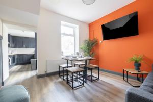 a living room with a table and a tv on a wall at City Rooms in Derry Londonderry