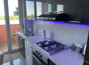 a kitchen with a stove and a counter top at Nada apartman in Vukovar