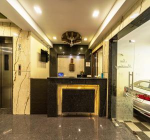 a lobby with a fireplace in a room with a car at SAU Residency in Kanchipuram