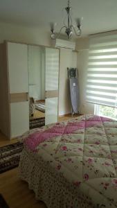 サパンジャにあるApartment Taybaのベッドルーム1室(ピンクのベッドカバー付きの大型ベッド1台付)