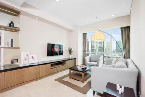 a living room with a couch and a tv at Lanea by Kozystay - Setiabudi in Jakarta