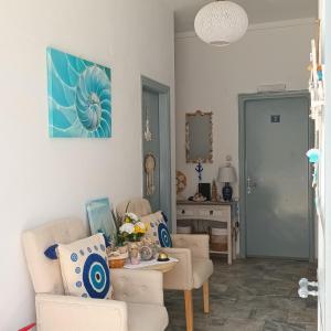 a living room with two chairs and a table at Massouri Rooms in Masouri