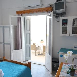 a bedroom with a door open to a patio at Massouri Rooms in Masouri
