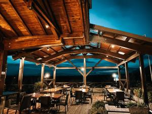 un grupo de mesas y sillas en una terraza por la noche en Hotel Oskar Zaplata, en Preddvor