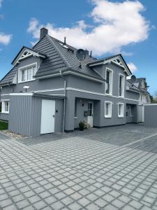 a large house with a driveway in front of it at Haus Q Superior - Hälfte 1 in Zingst