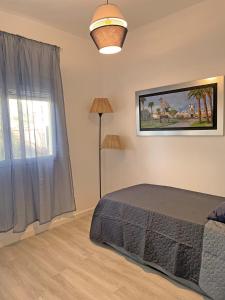 a bedroom with a bed and a lamp and a window at Casa Gloria in El Puerto de Santa María +30 photos