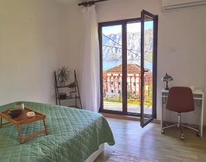 una camera da letto con un letto, una scrivania e una finestra di Villa Seashell a Prčanj